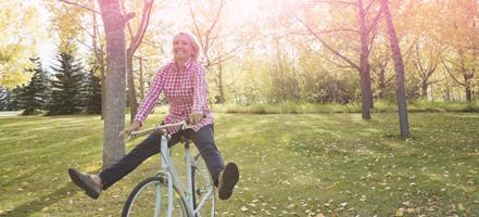Kuva nuoresta naisesta pyöräilemässä. Kuva kuvastaa kuinka voit olla huoleton ja aktiivinen kuukautistenkin aikana. 